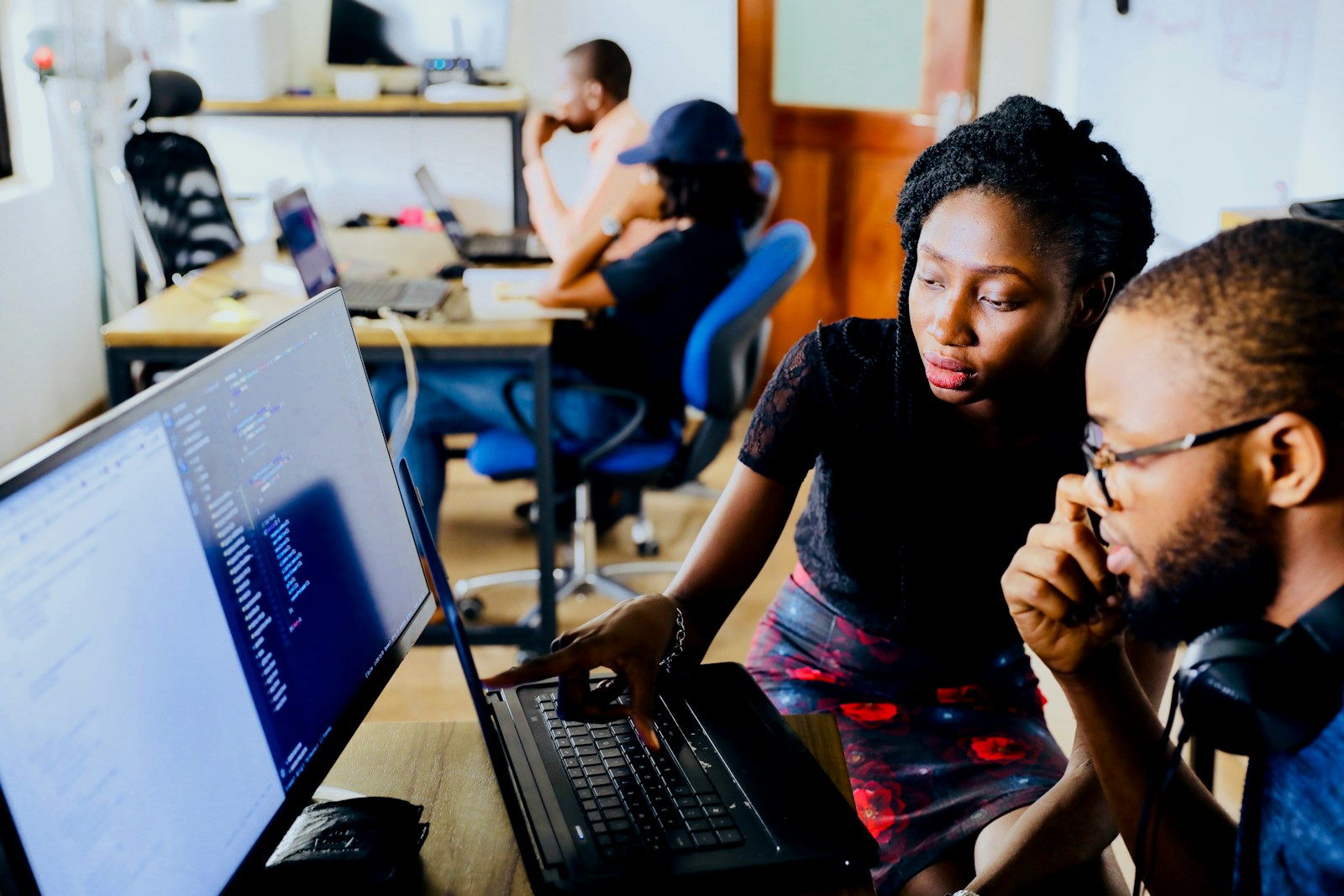 Developers collaborating at a computer with code on screen