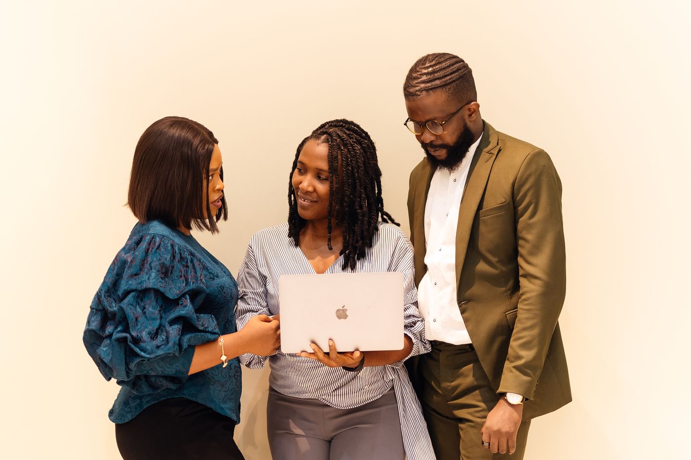 Three business professionals collaborating around a laptop