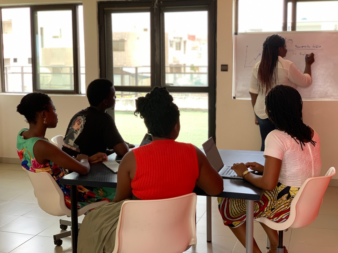 Workshop participants learning with laptops and a whiteboard